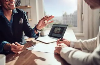 A tenant speaking with a landlord as he hands over the keys to a property. SparkRental property management software